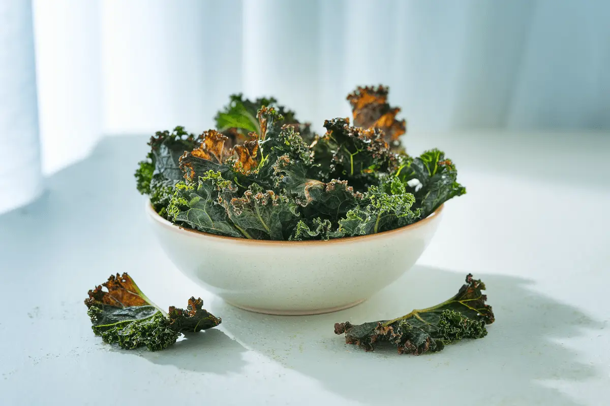 A bowl of crispy smoked paprika kale chips served as a healthy snack.